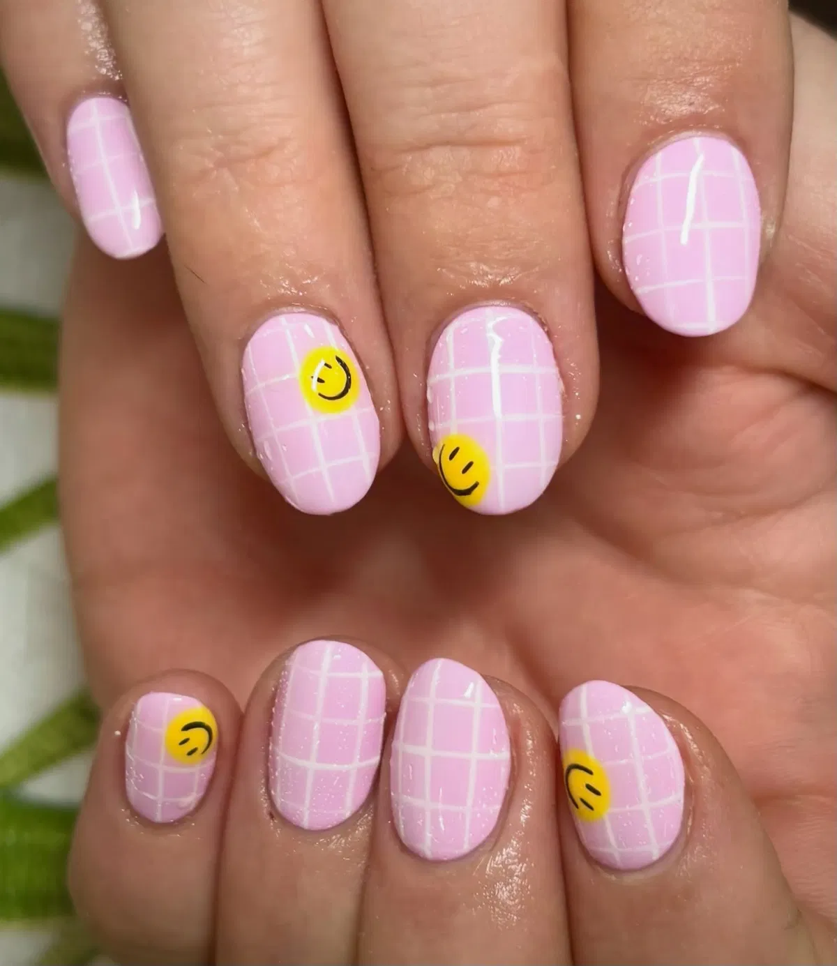 Pink grid nails with yellow smiley details