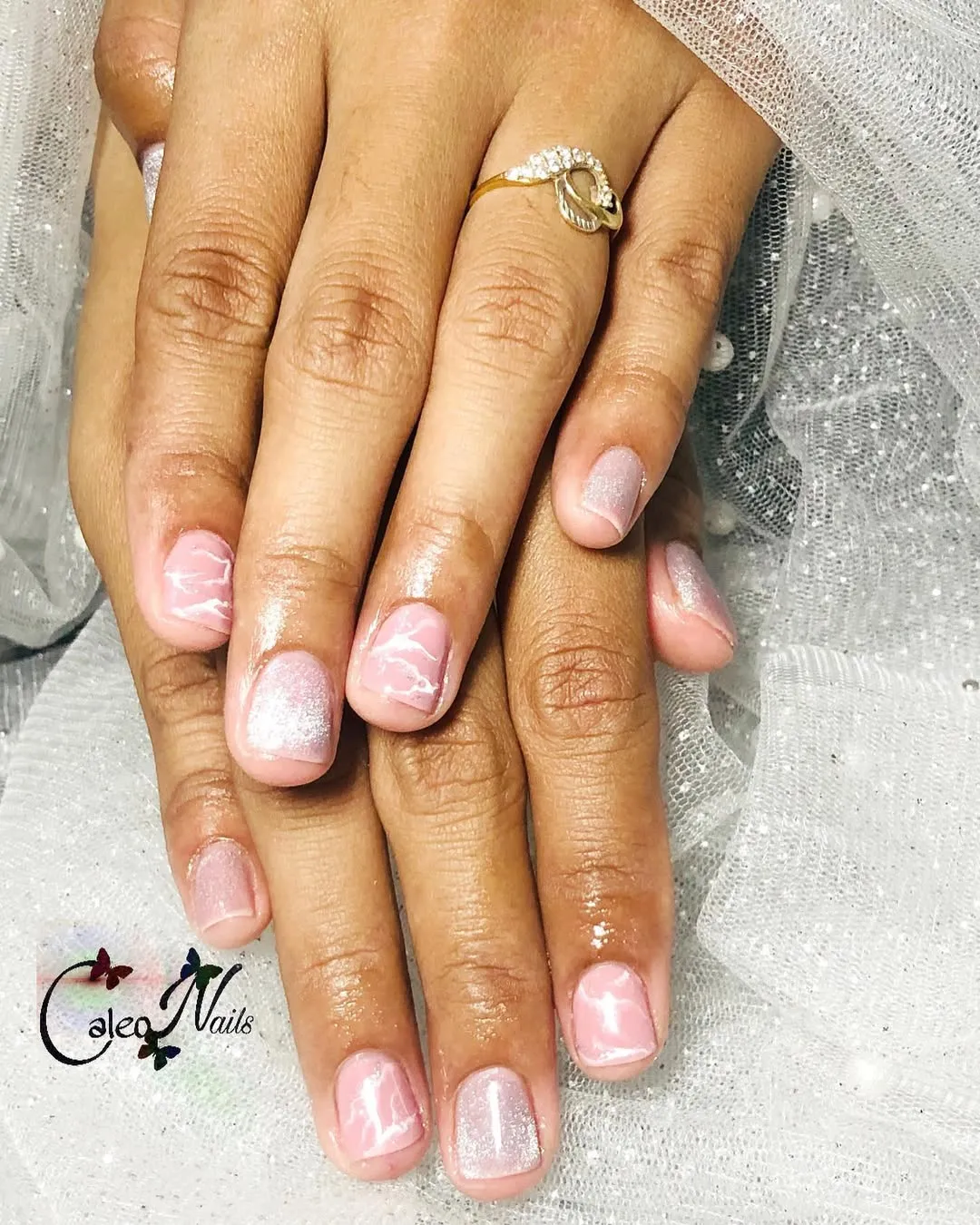 Short pink nails with white marbling and soft shimmer