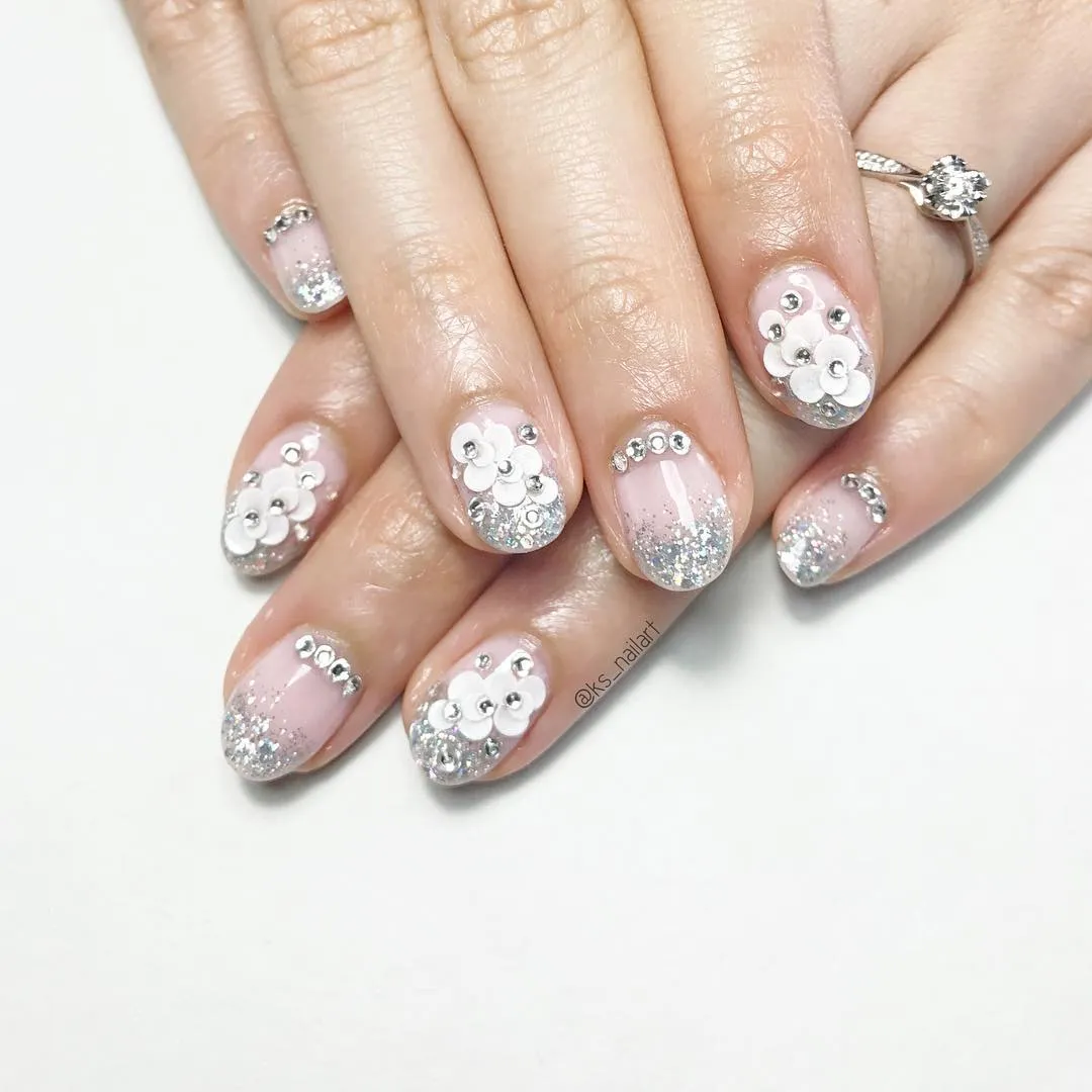 Short pink glitter-gradient nails with 3D white flowers