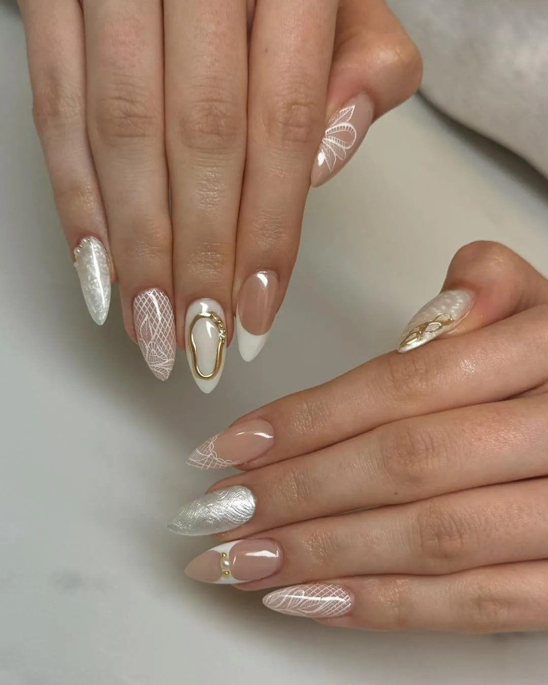 Long nude-and-white lace linework with a gold-framed accent nail