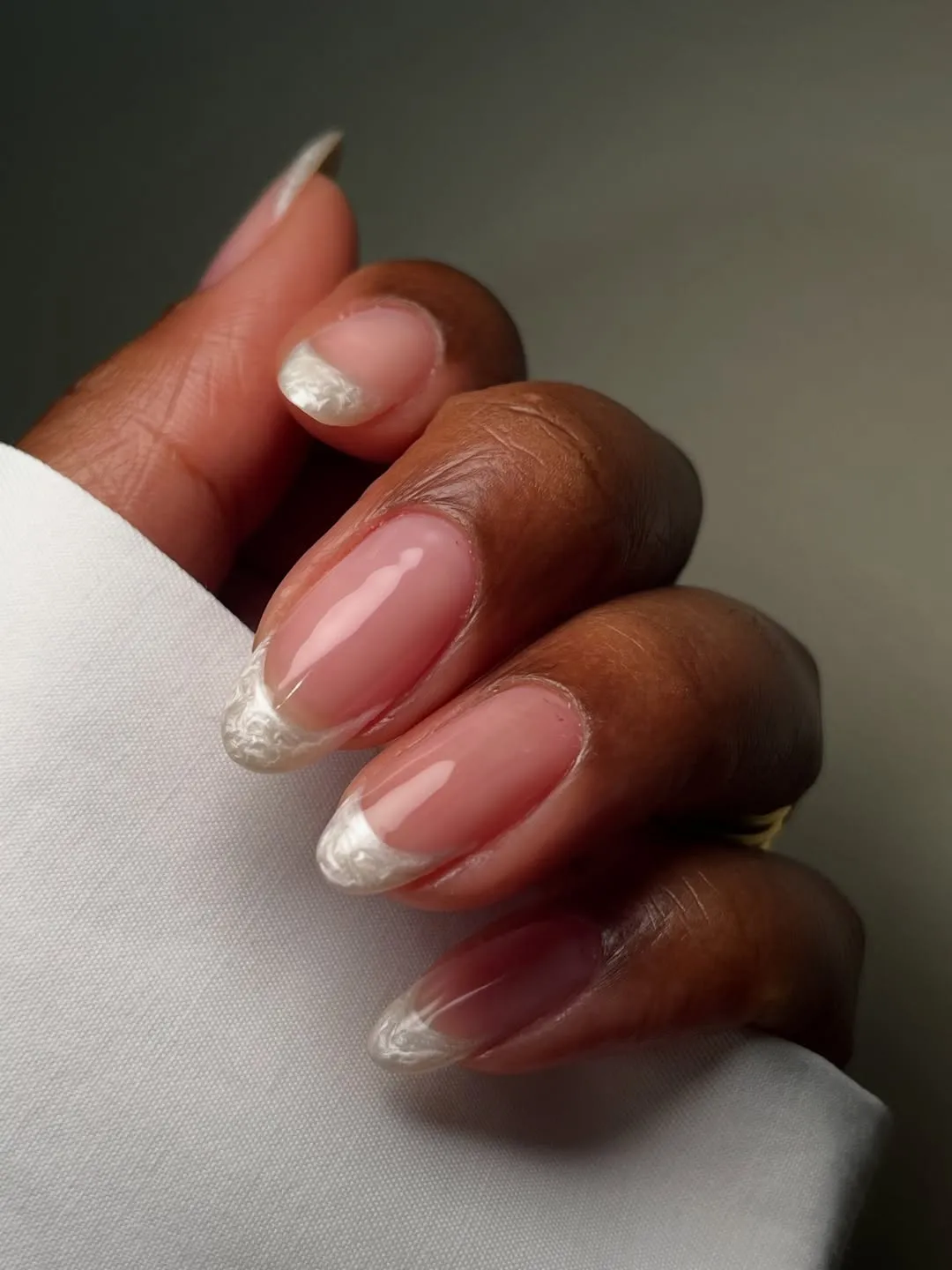 Glossy pink almond nails with pearly white French tips