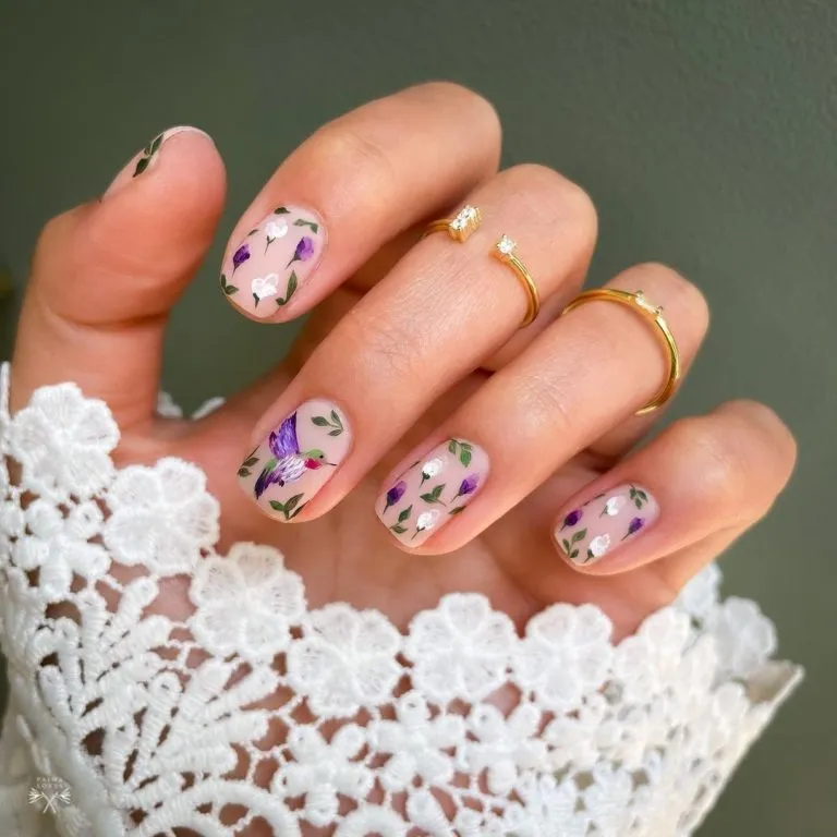 Short nude nails with purple-and-green floral nail art