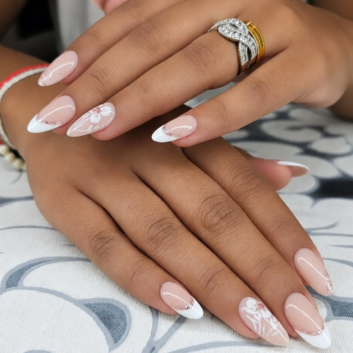 Almond French tips with rose-gold glitter arcs and floral line art
