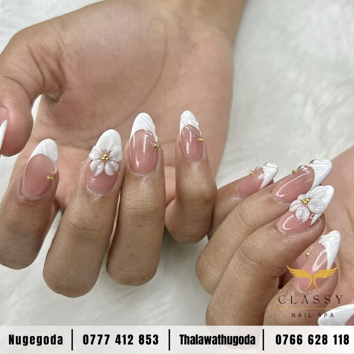 Sheer pink French tips with raised white flowers and gold beads