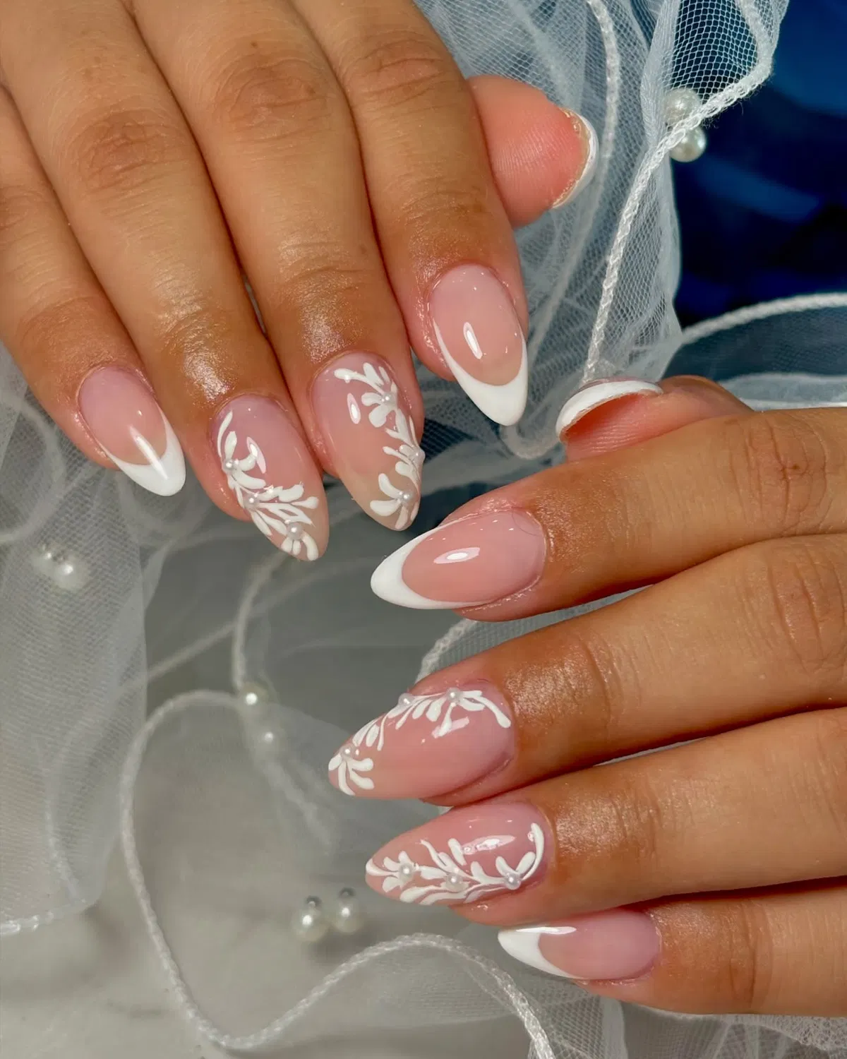 Pink French tips with white vine art and pearl-like accents