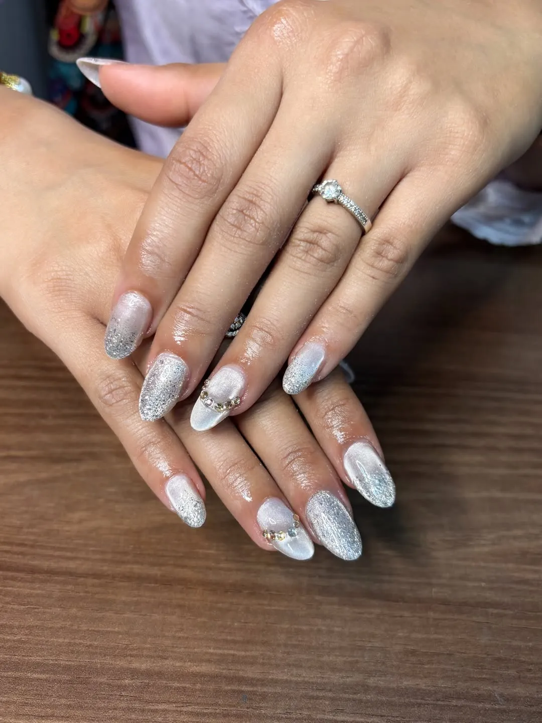 Silver glitter ombré almond nails with rhinestone cuticle accent