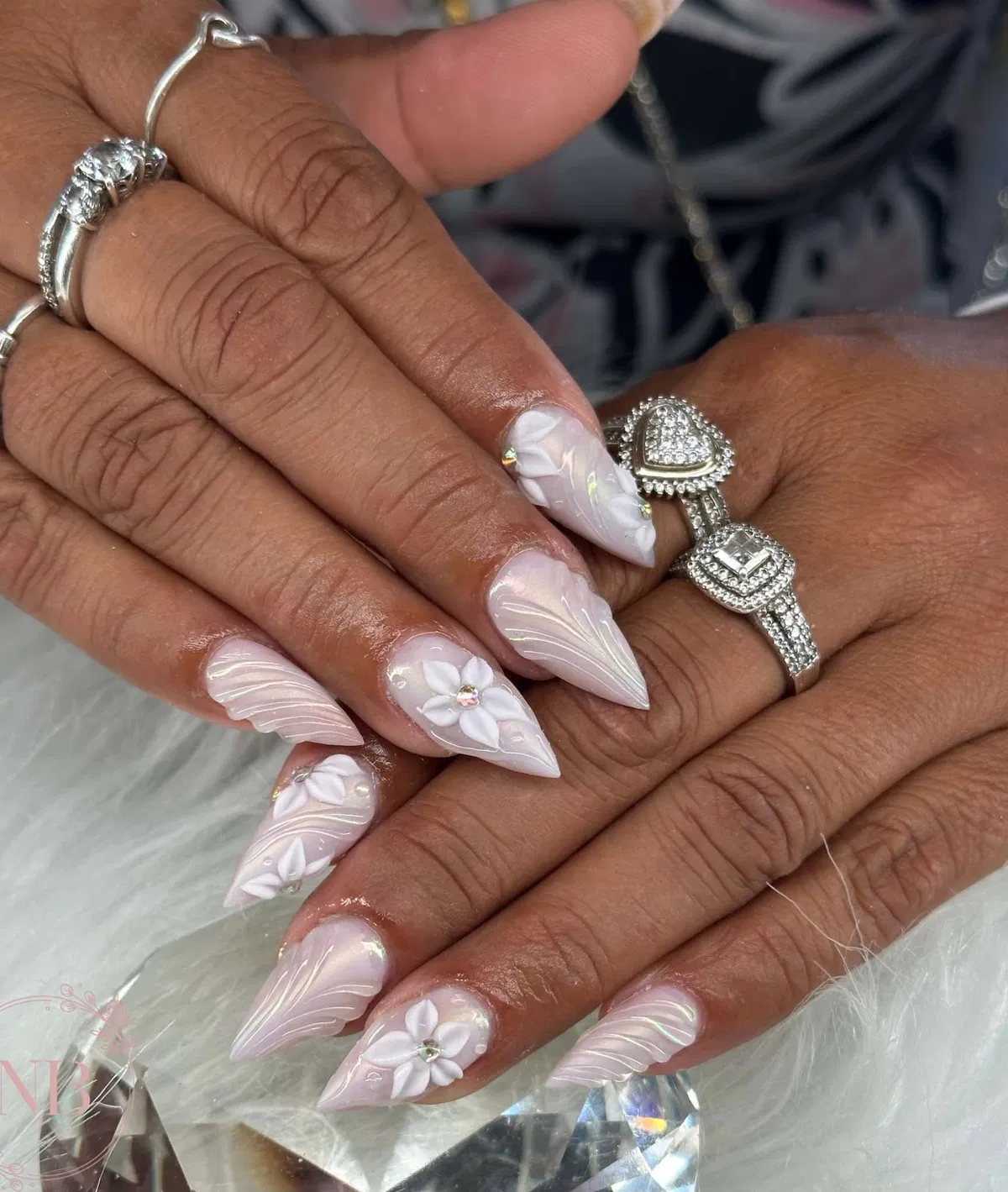 Pink stiletto nails with raised white swirls and 3D flowers