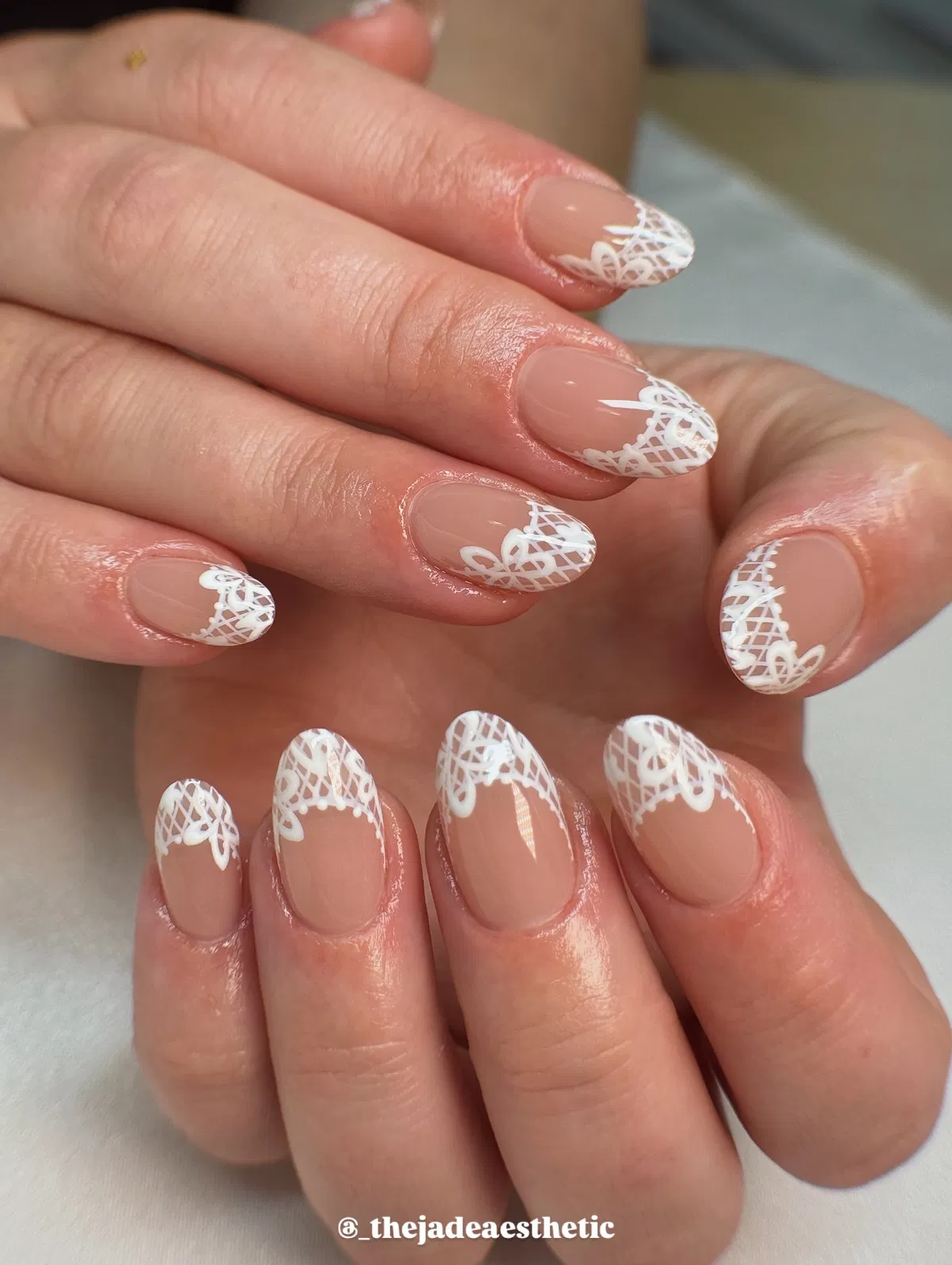 Nude oval nails with white lace tip detailing