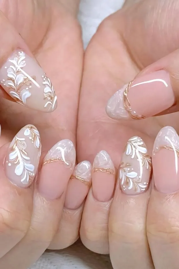 Nude nails with white leaf motifs and marbled tips