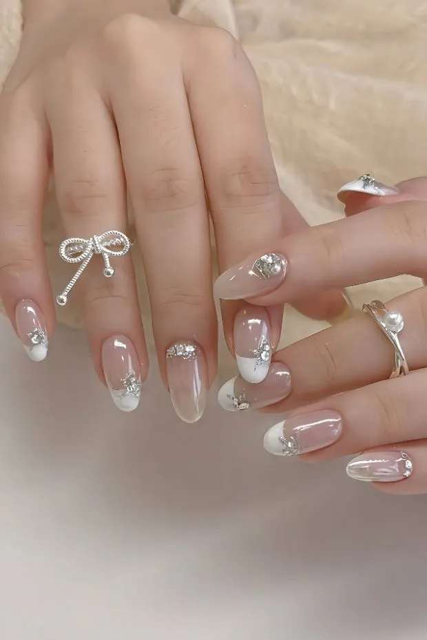White French tips with rhinestones and rings