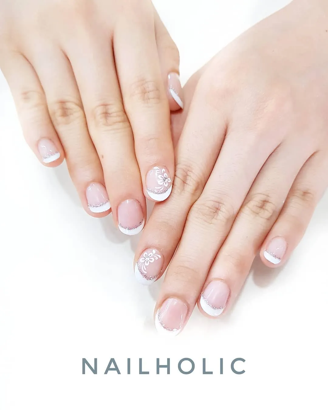 Short French tips with silver glitter lines and floral accents