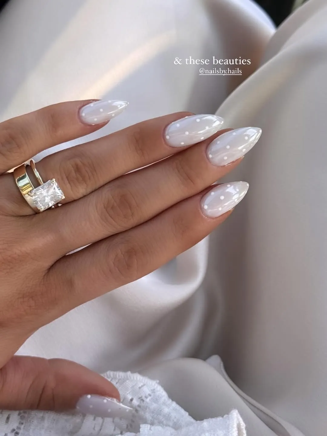 Glossy white almond nails with polka dots