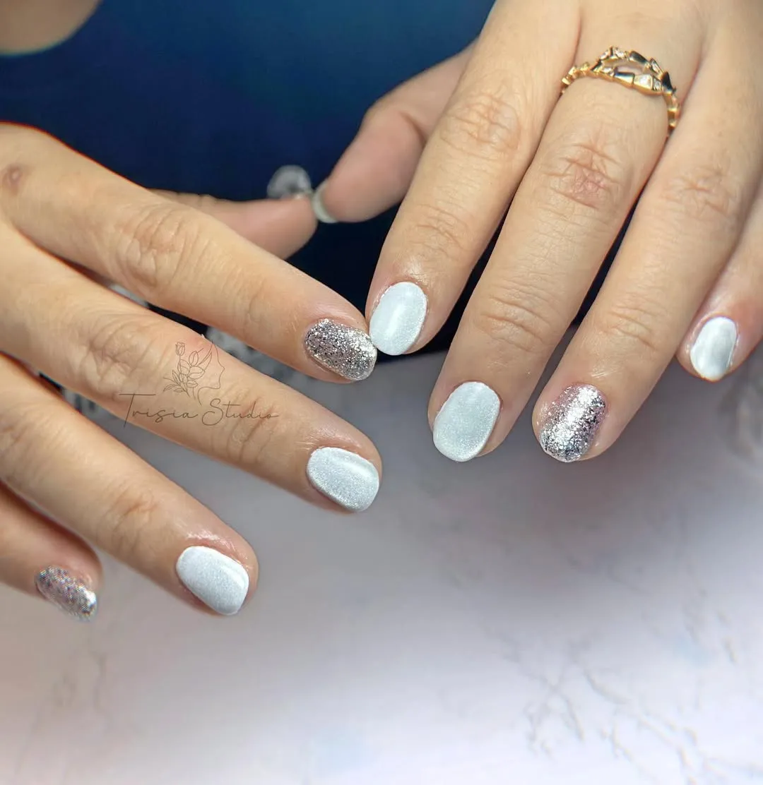 Pearly white nails with silver glitter accents