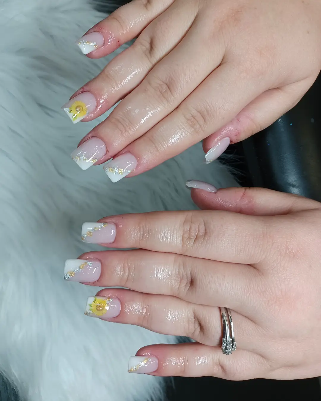 White-tipped square nails with glitter diagonals and yellow floral accents