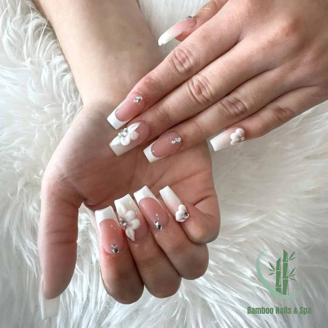 French tips with raised white flowers and small rhinestone accents