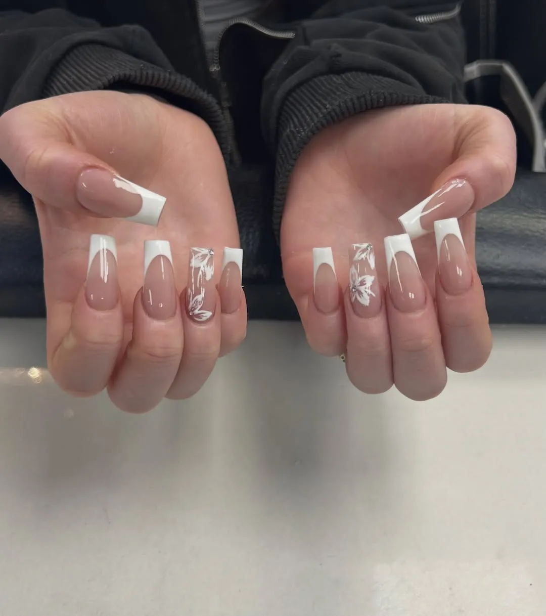 Long square French tips with white botanical accents