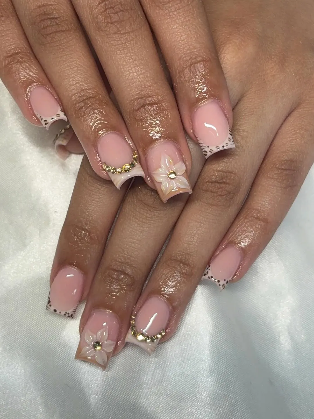 Pink square nails with dotted French tips and raised flower accent