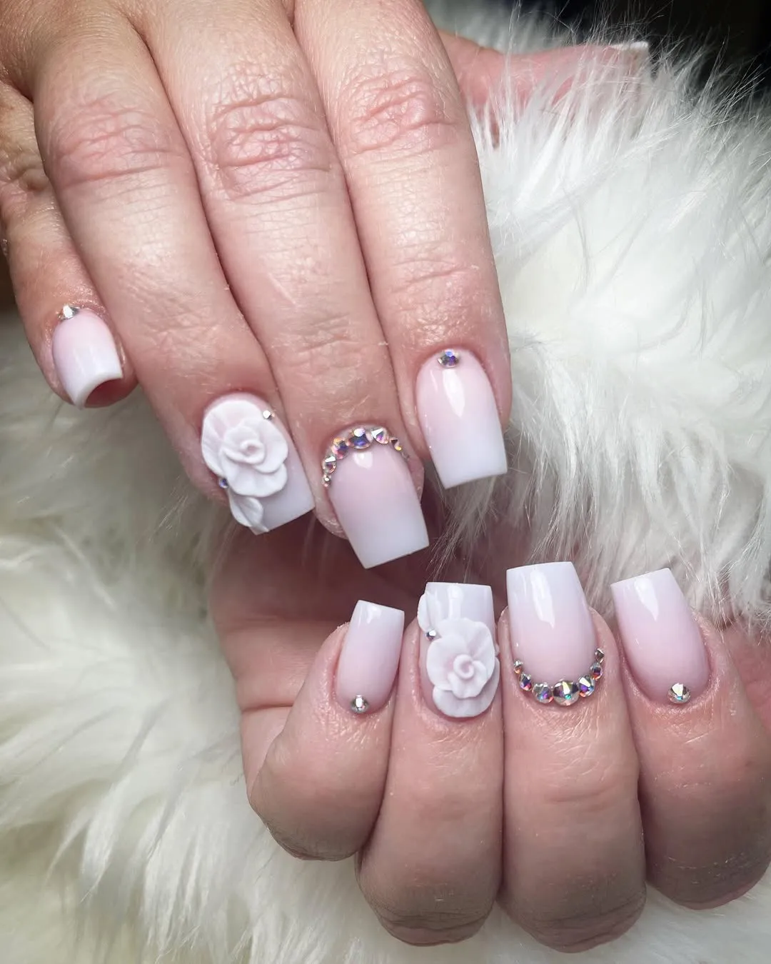 Pink-to-white ombré with raised white roses and rhinestone crescents