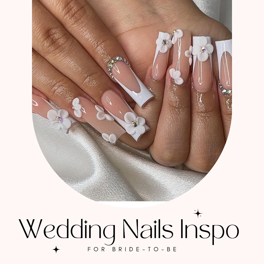 Long French tips with 3D white flowers and rhinestone arcs