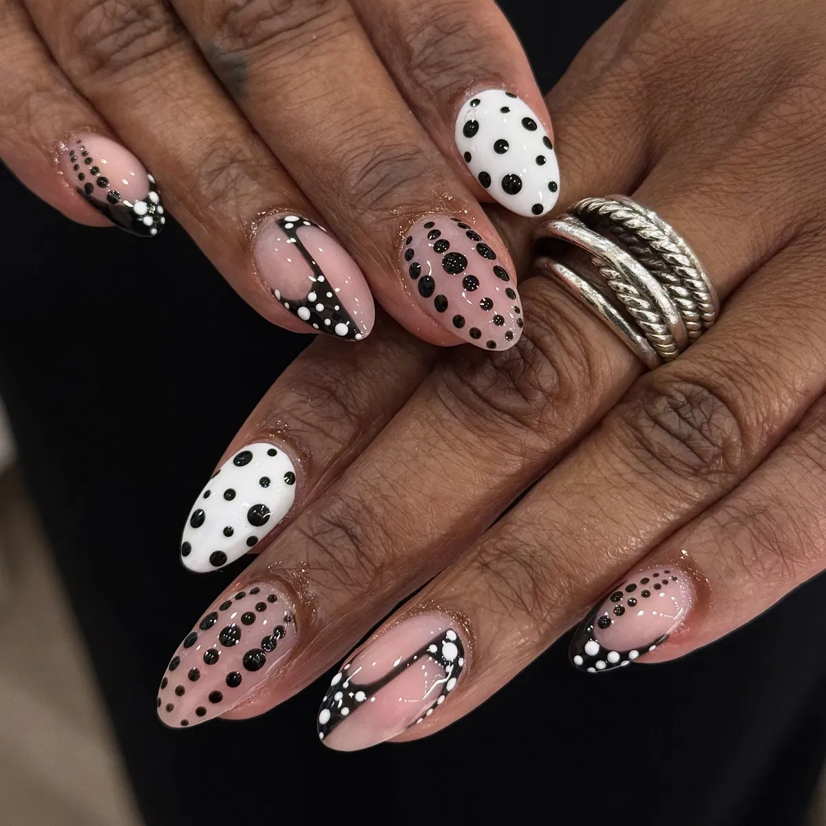 Mixed nude and white bases with varied-size polka dots and curved black tips