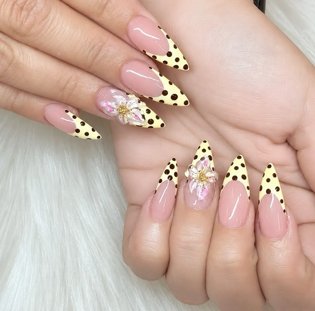 Stiletto nude base with bold brown polka-dot yellow tips and 3D flowers
