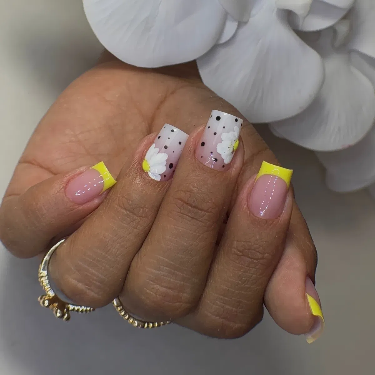 Square yellow French tips with dotted floral accent nails
