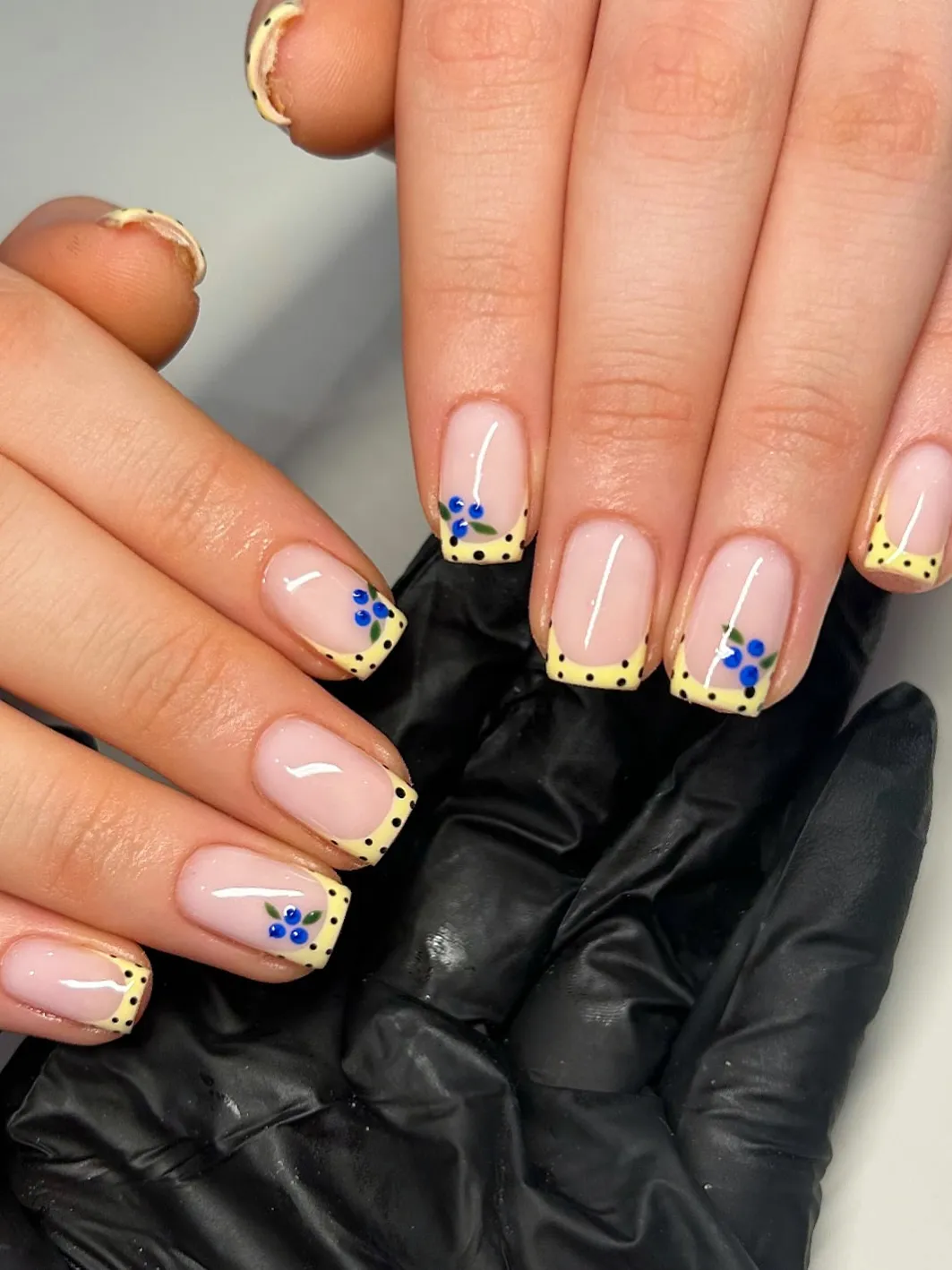 Square yellow polka-dot French tips with blue berry accents