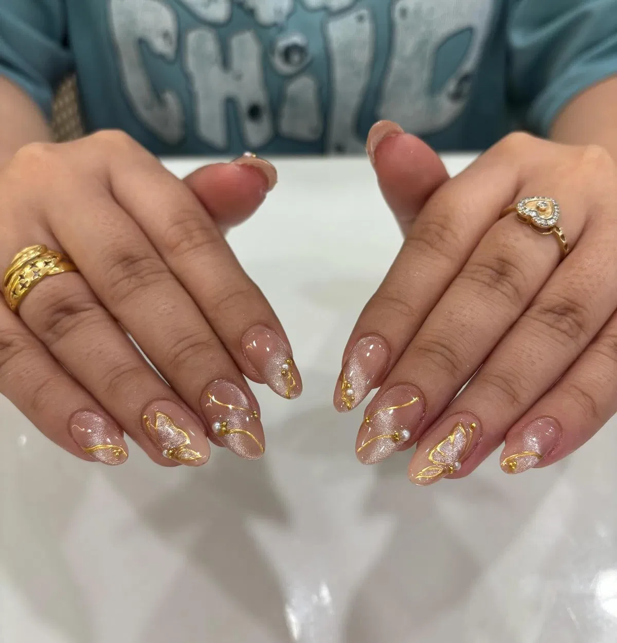 Shimmery nude with fine gold linework and butterfly accents