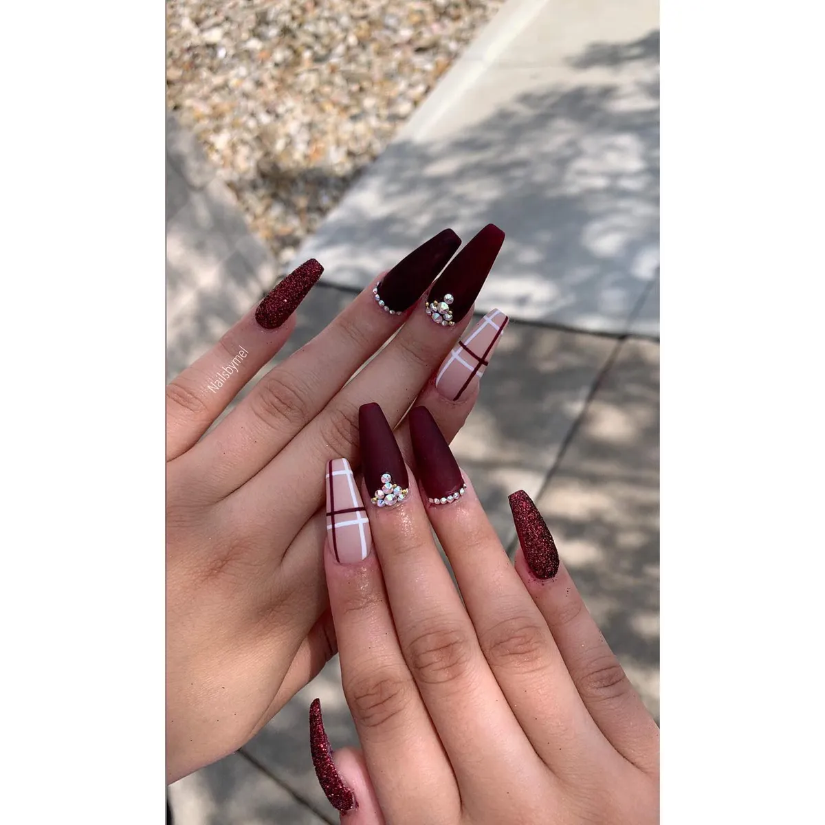 Matte burgundy coffin nails with plaid and rhinestone clusters