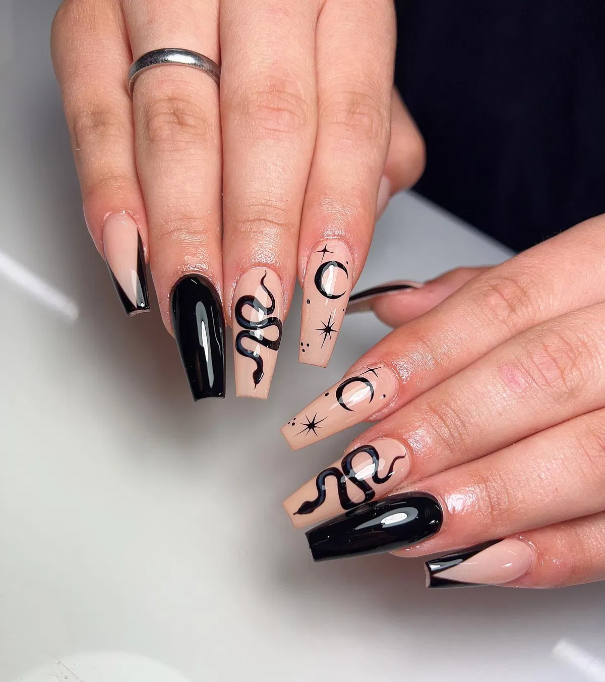 Nude-and-black celestial and snake nail art