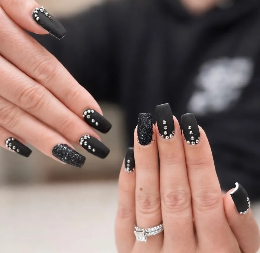 Matte black coffin nails with rhinestones and glitter accent