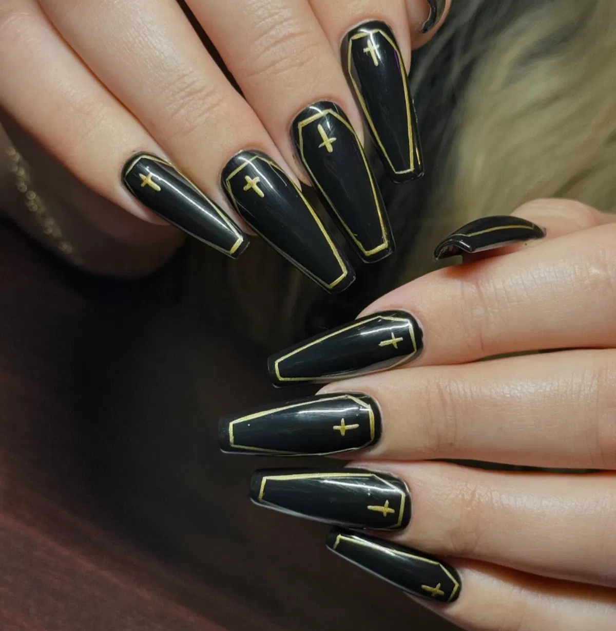 Glossy black coffin-outline design with gold crosses
