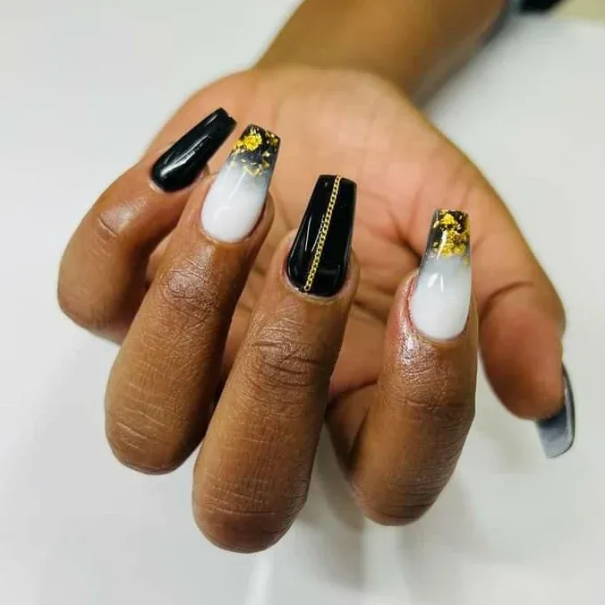Pink and nude stiletto nails with black-and-white polka dot detailing