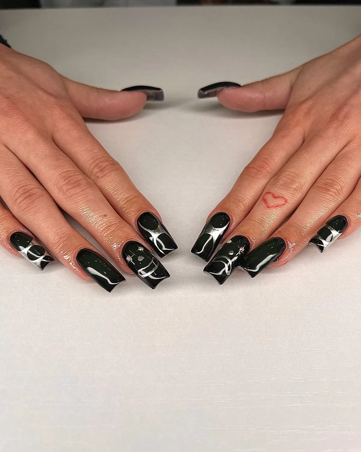 Black coffin nails with gold butterfly motifs and iridescent gem embellishments