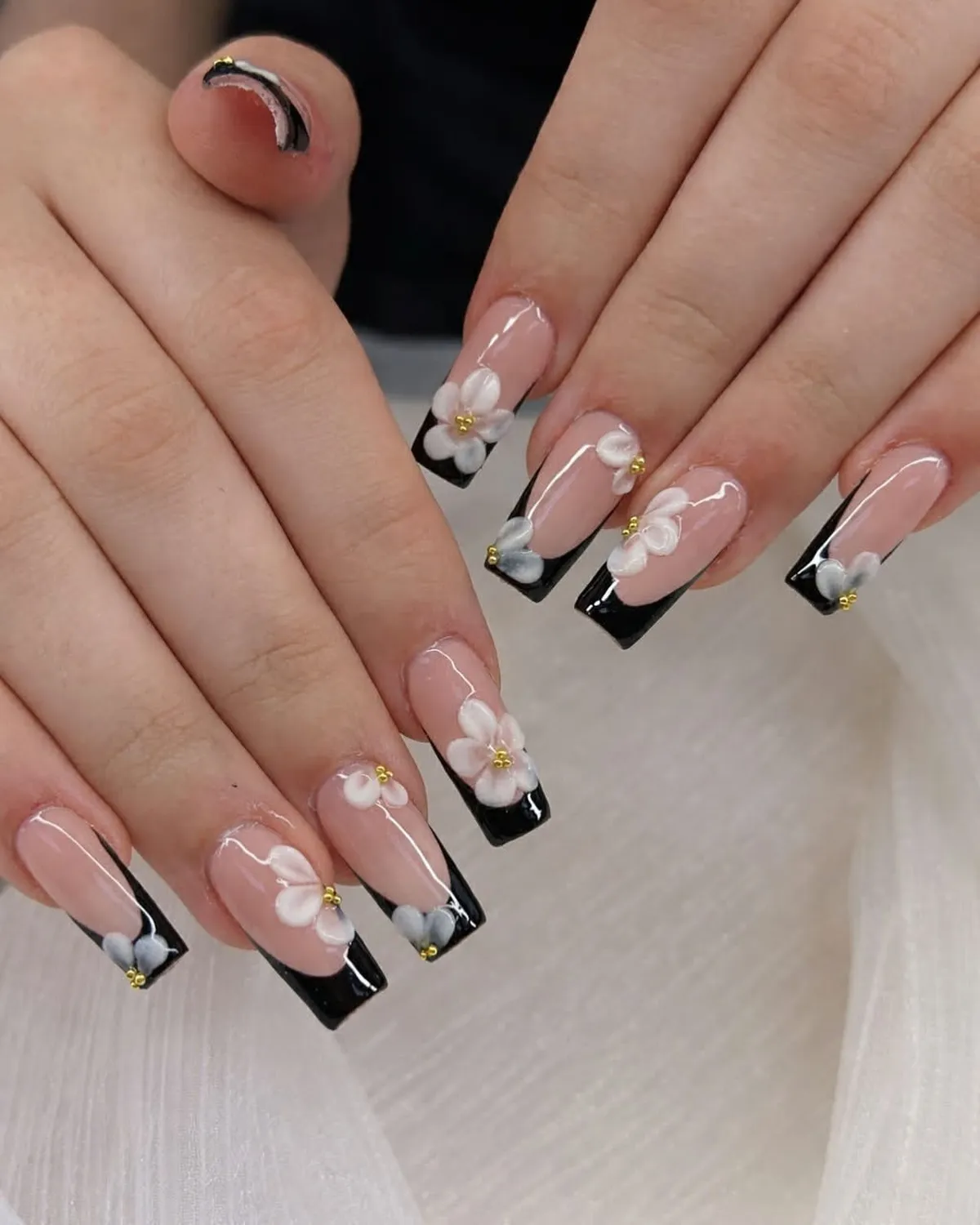 Black French tips with raised white floral decorations