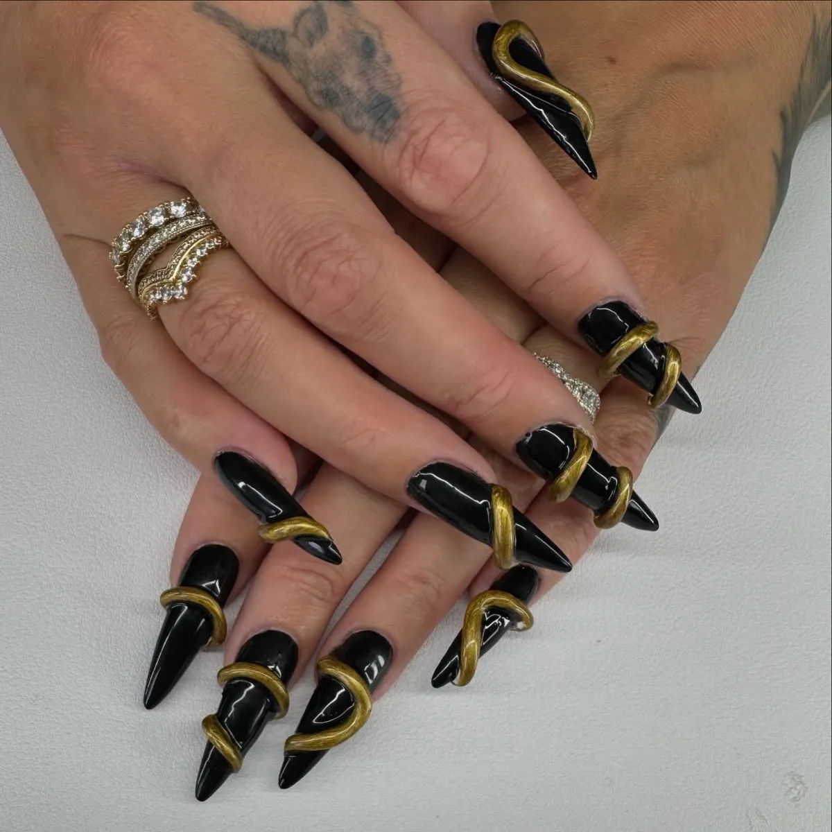 Glossy black stilettos with gold spiral wrap accents