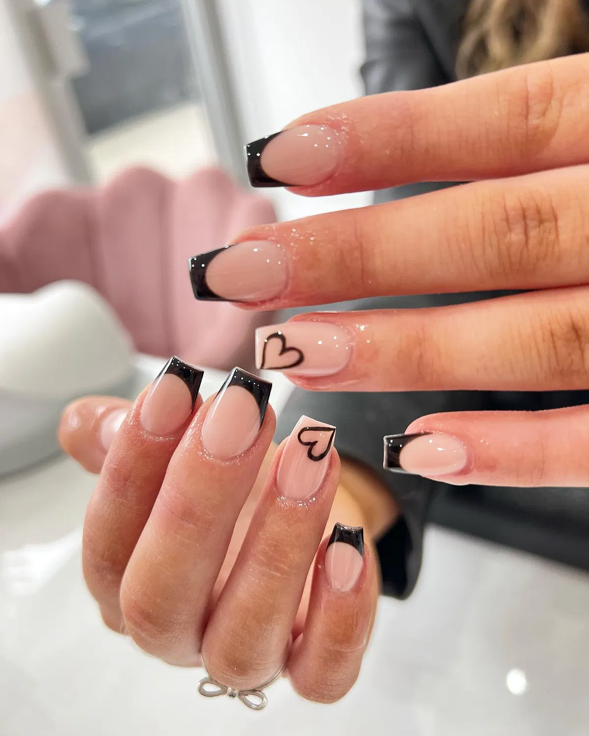 Glossy black French tips with outlined heart accents