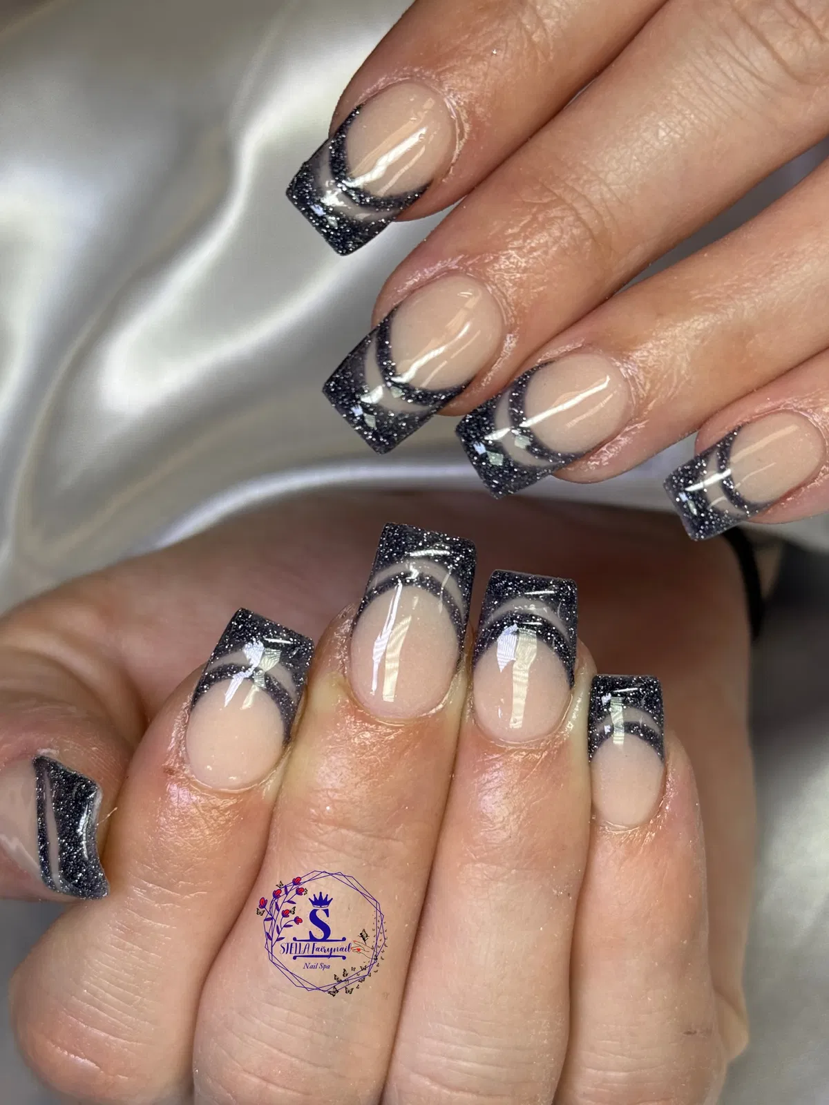 Glittery black tips with curved negative-space arcs