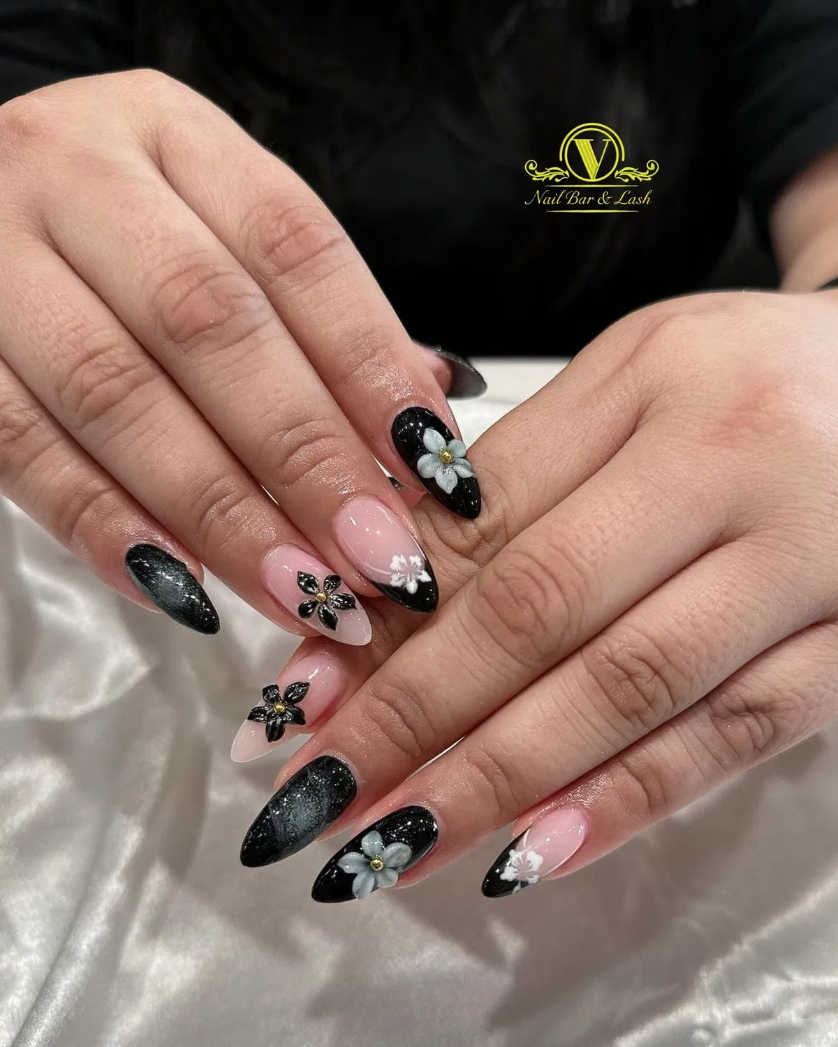Black and nude nails with black tips and raised floral decorations