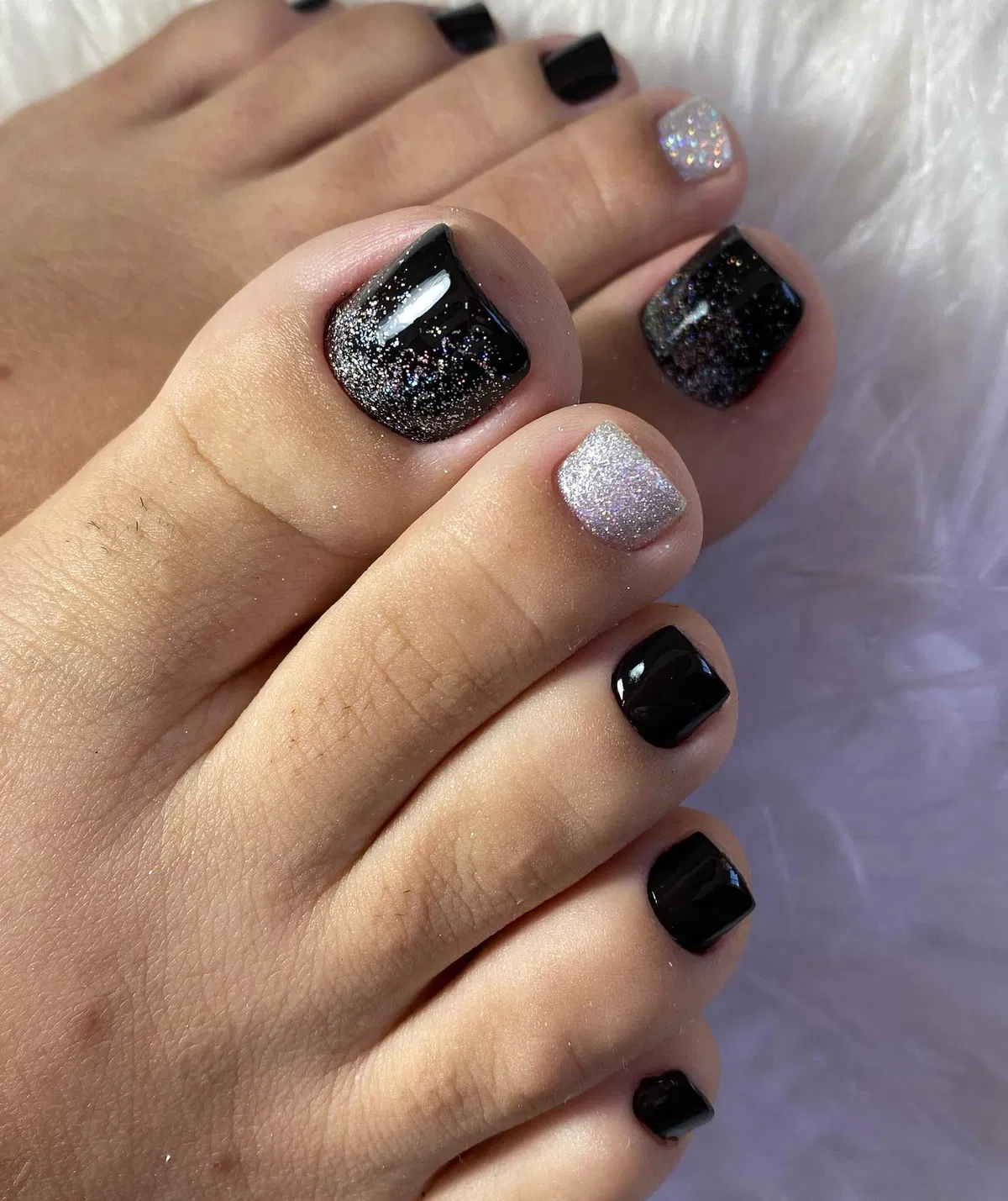 Black pedicure with glitter and silver accent nail