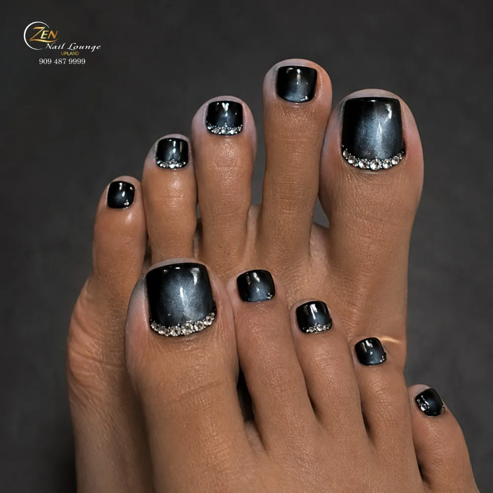 Glossy black pedicure with curved rhinestone cuticle lines