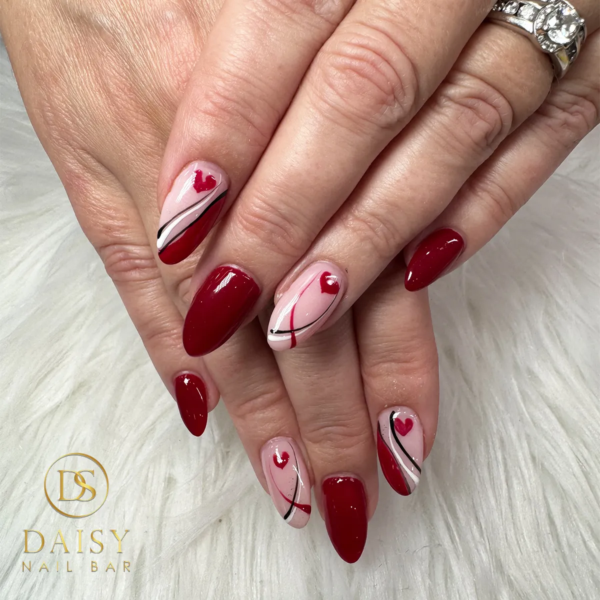 Deep red solids with pink heart-and-stripe accent nails