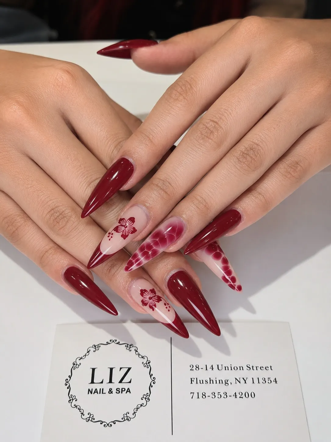 Extra-long stiletto reds with floral and patterned accent nails