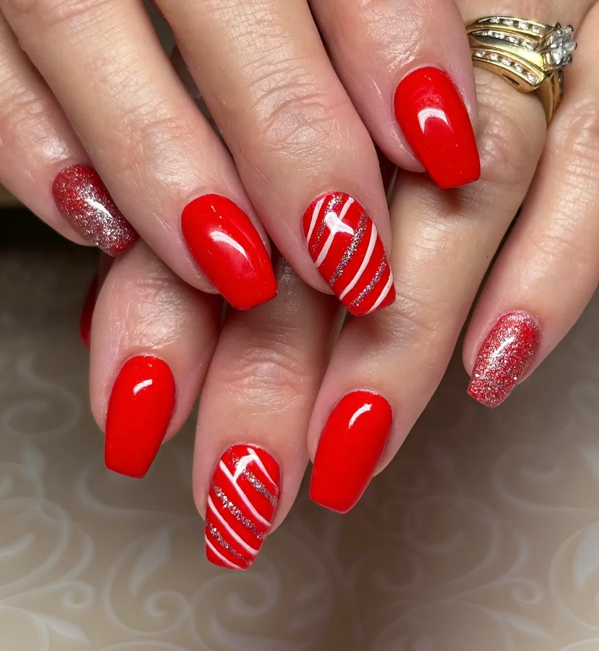 Glossy bright red square nails with glitter and striped accents