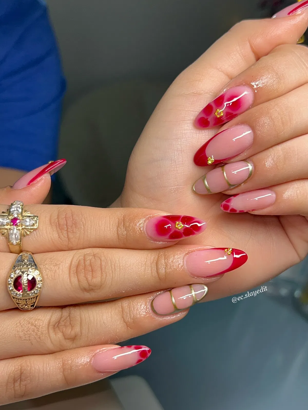 Nude-pink almond nails with red tips and gold line accents