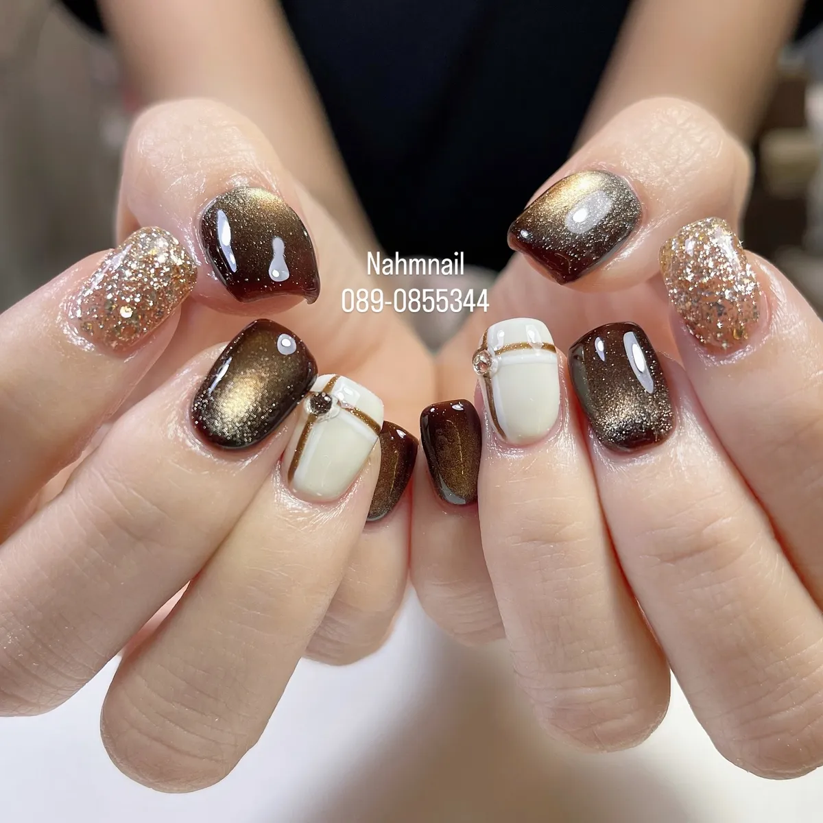 Gold-shimmer brown with glitter accents and striped white nails