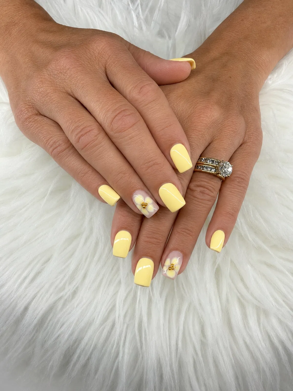 Solid buttery yellow with white floral accent nails