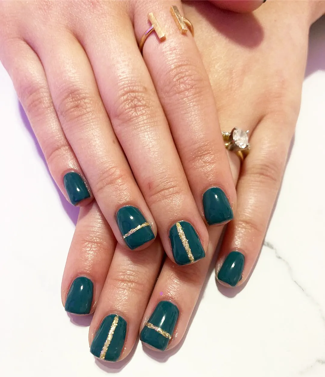 Teal nails with minimal gold glitter striping