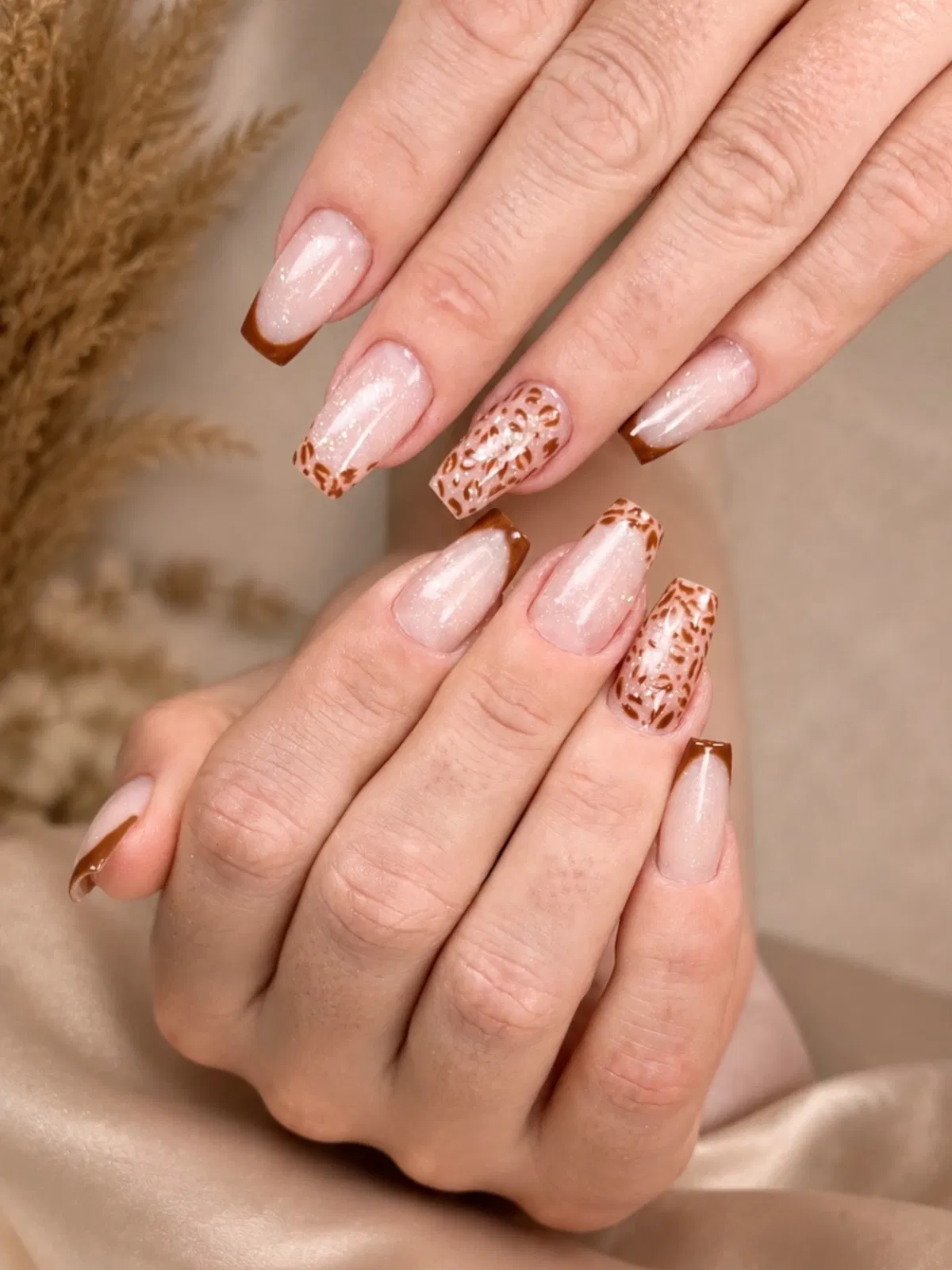 Sparkly pale pink with brown French tips and leopard accents