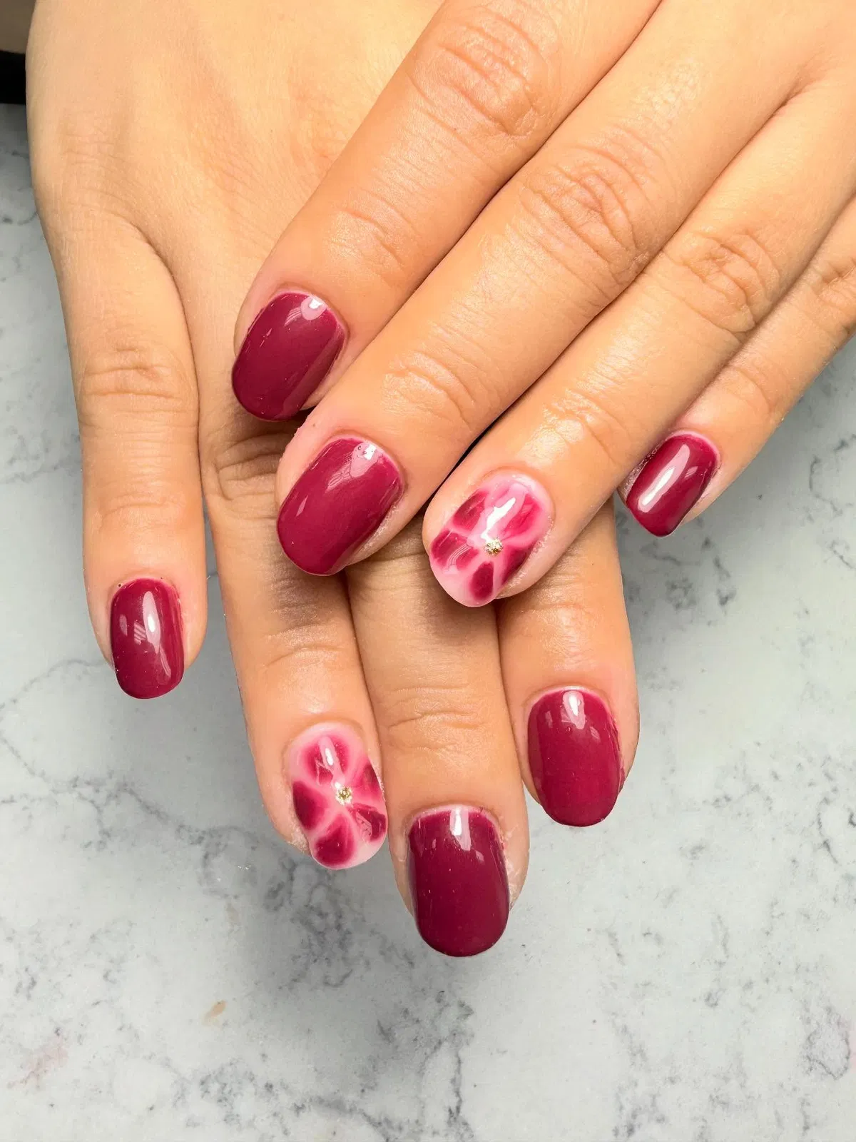 Deep berry gloss with pink flower accent nails